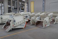Row of heavy-duty industrial machinery inside modern factory facility.