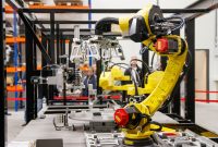 aap-how-to-select-the-right-industrial-automation-system-for-your-factory-1790871477 Close-up of a yellow industrial robotic arm in action at a modern manufacturing facility.