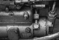 Detailed black and white photo of vintage machinery components, highlighting aged metal textures.