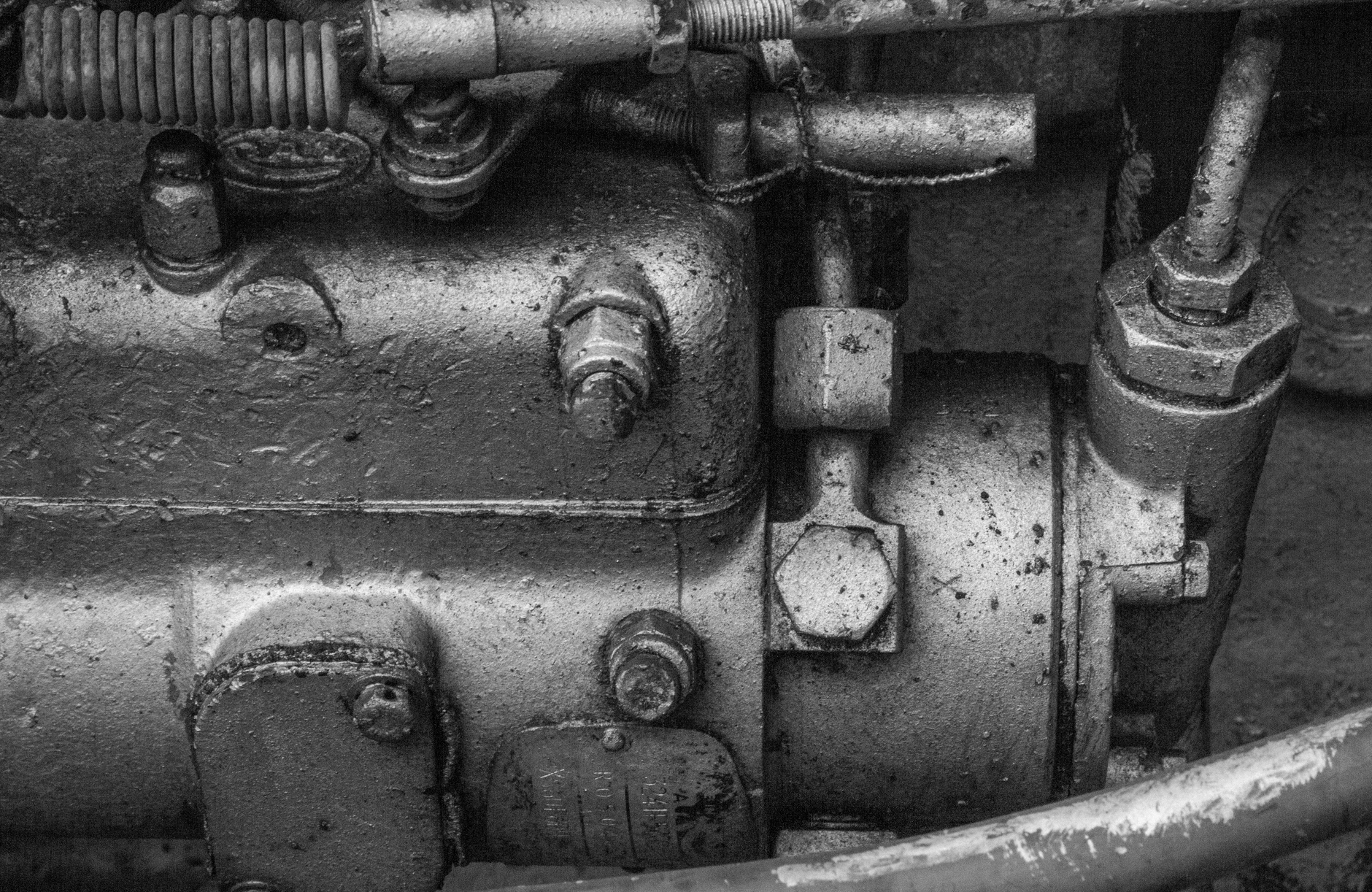 Detailed black and white photo of vintage machinery components, highlighting aged metal textures.