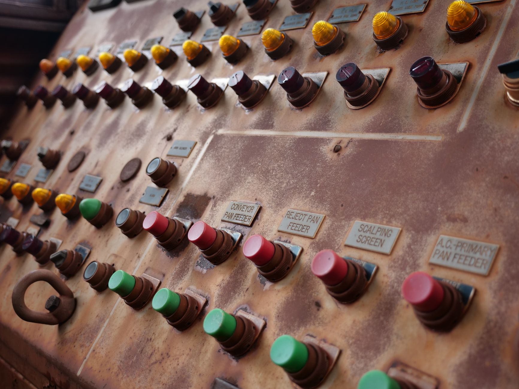 Vintage control panel with colorful buttons and industrial labels.